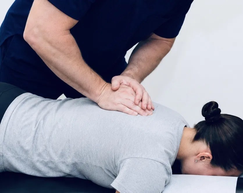 A TRUForm doctor performing a thoracic chiropractic adjustment at Texas Functional Health Centers in Dallas, TX