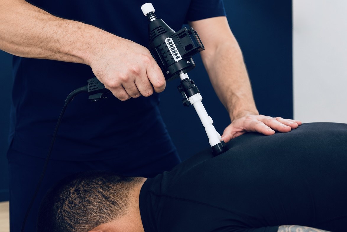 A TRUForm doctor delivering an instrument-assisted ArthroStim adjustment to a patient&rsquo;s low back at Texas Functional Health Centers in Dallas, TX