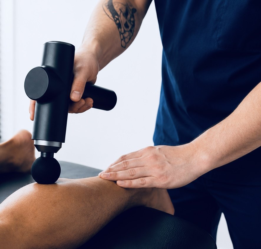 A TRUForm provider applying percussion therapy to a patient&rsquo;s leg at Texas Functional Health Centers in Dallas, TX