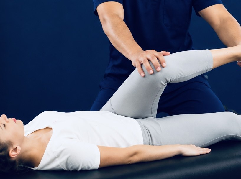 A TRUForm provider guiding a patient through an assisted contract-relax stretch at Texas Functional Health Centers in Dallas, TX